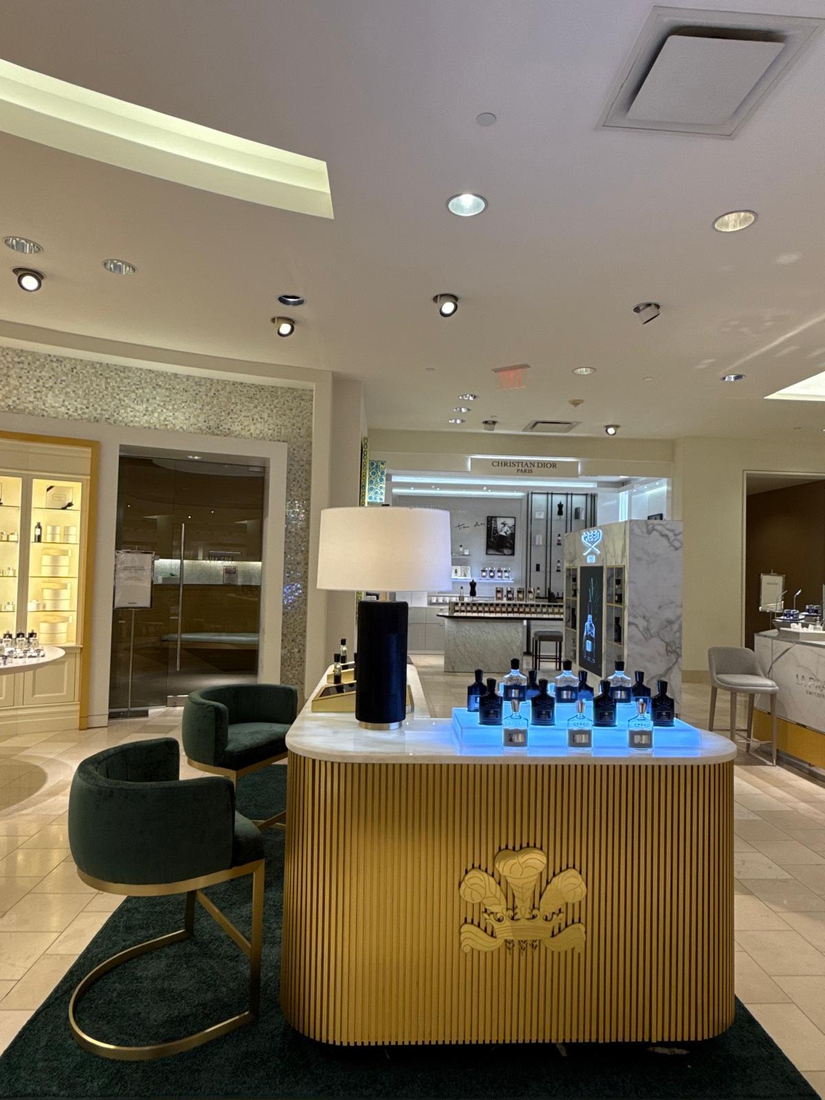 Creed fragrance counter marble countertop with brass accents and product display