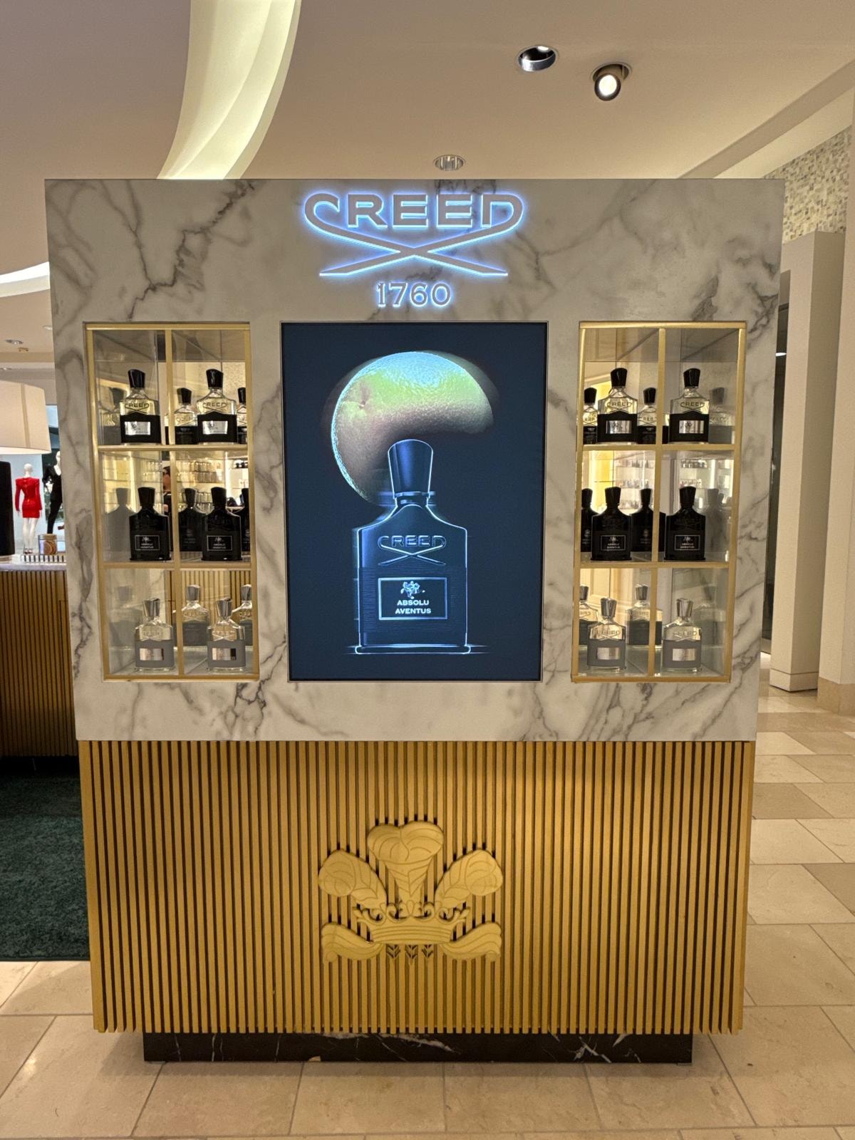 Creed 1760 neon sign backwall with gold display cases and digital screen