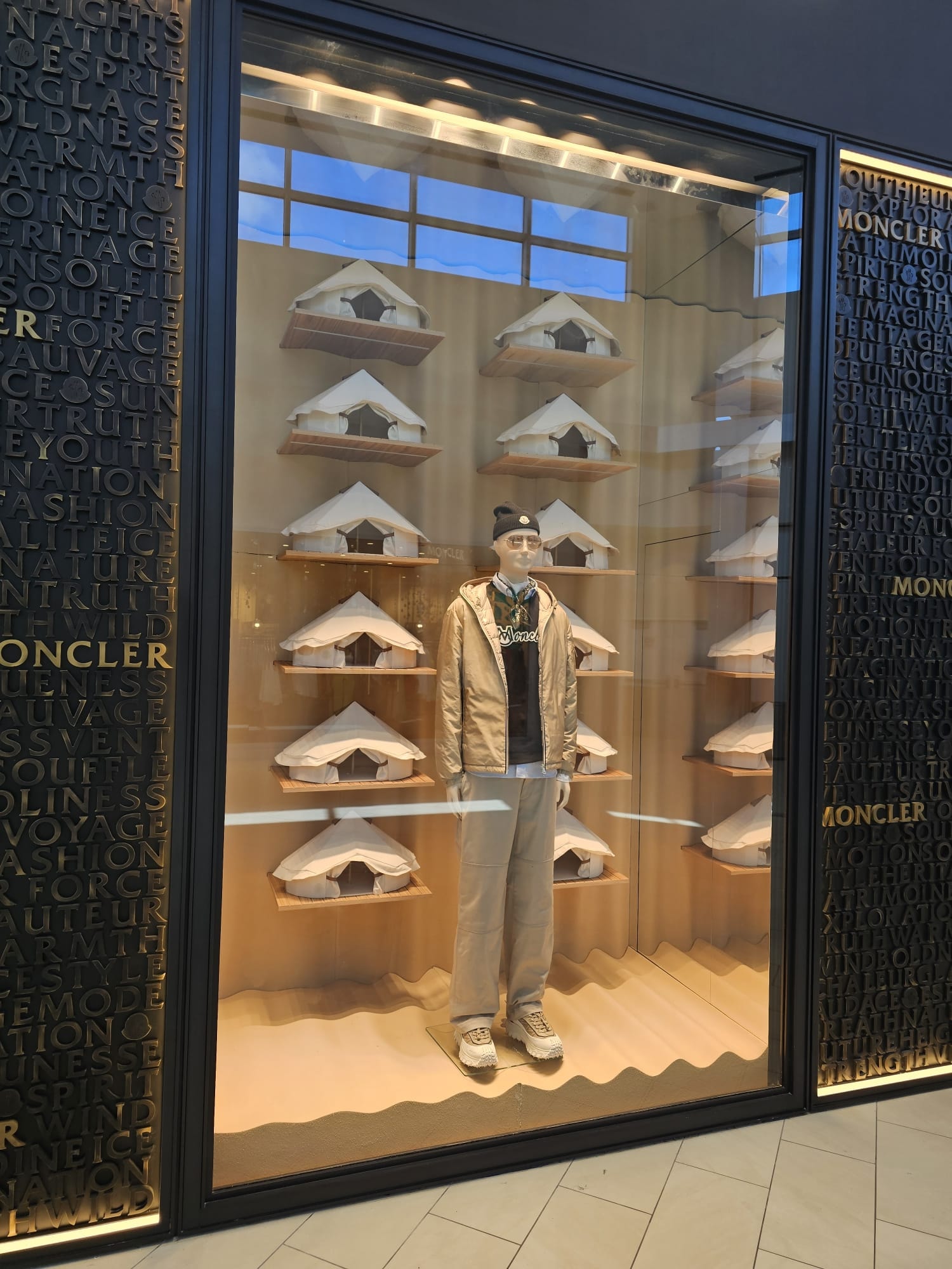 Moncler luxury retail window display with mannequin and birdhouse shelving