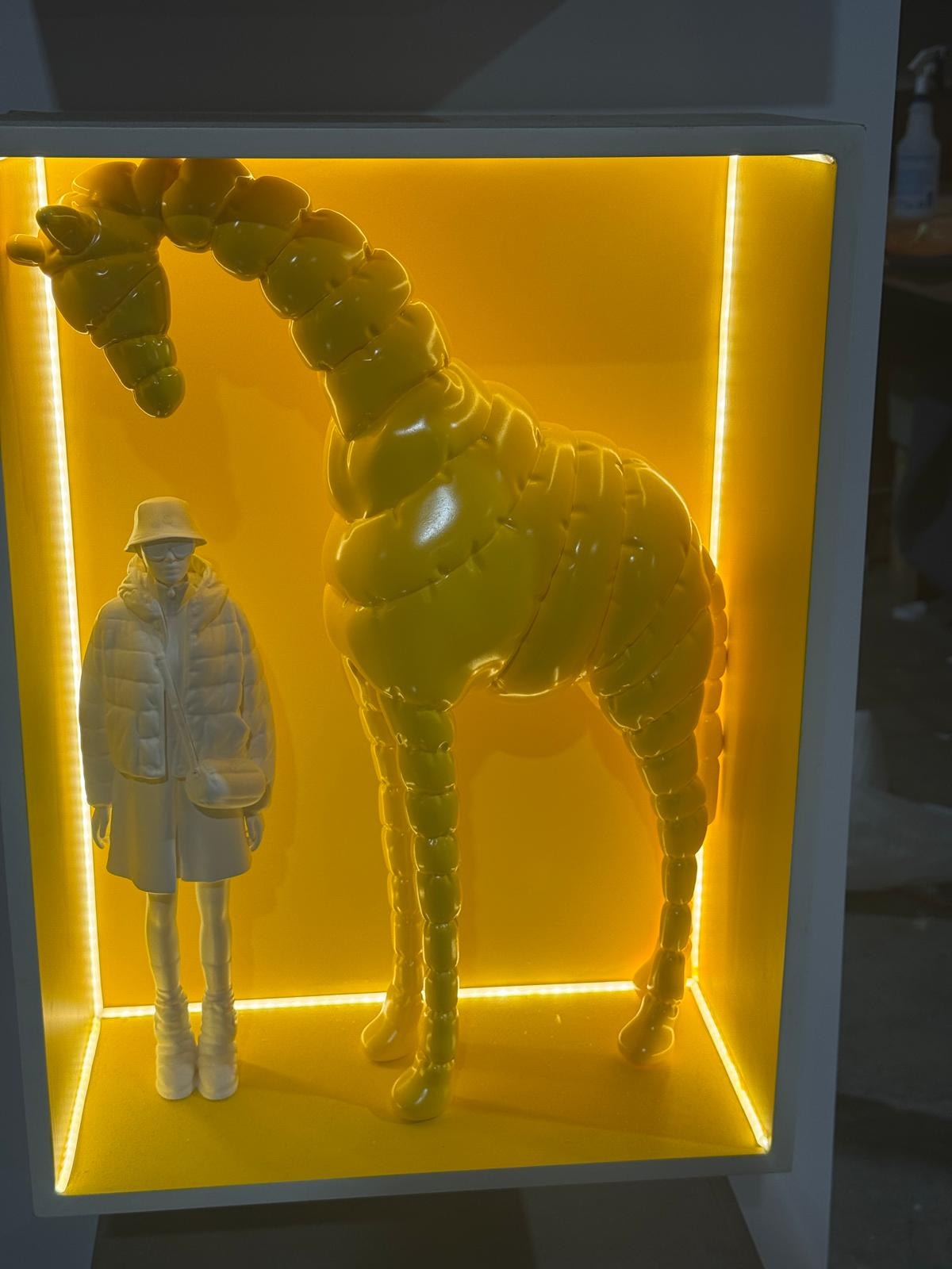 Multi-panel illuminated window display with neon-lit sculptural figures
